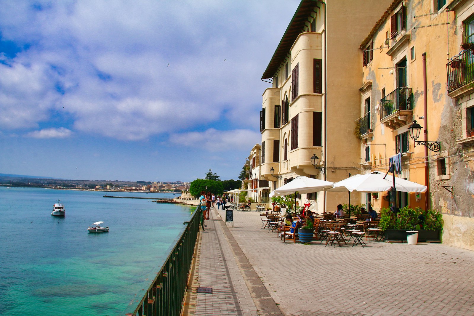 Waterfront promenade with cafes and buildings along the sea